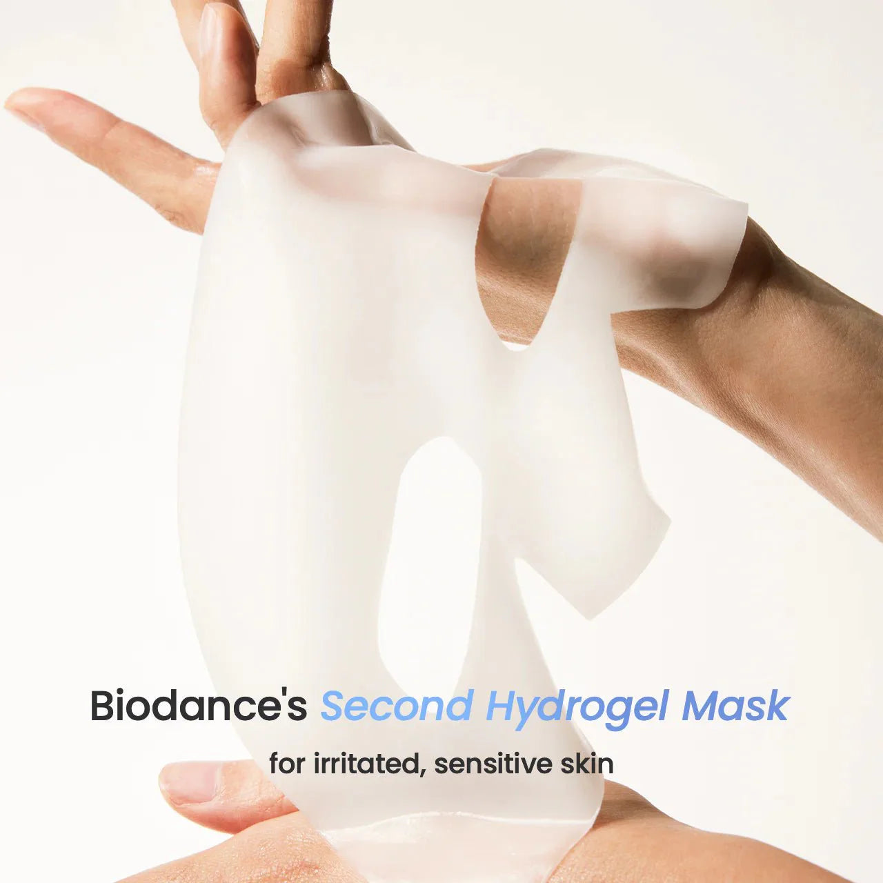 Hands holding a thick, white Biodance hydrogel mask for sensitive skin.