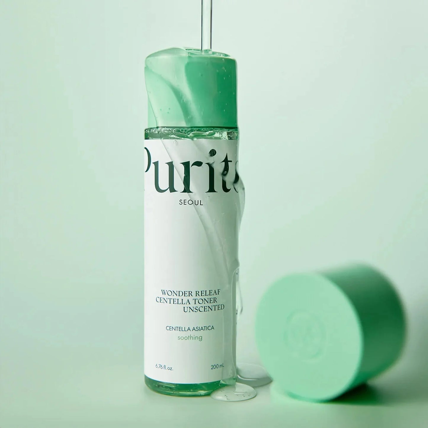 Purito Wonder Releaf Centella Toner bottle with a clear, hydrating liquid texture pouring over the cap.