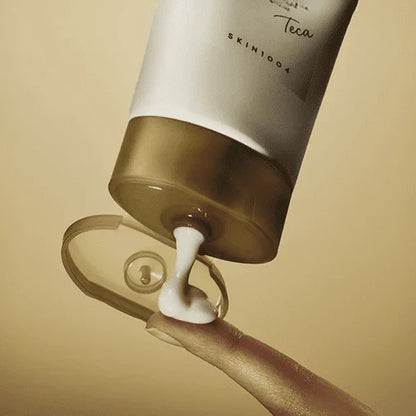 Skin1004 Madagascar Centella Teca Cream white tube with gold cap being squeezed onto a fingertip.